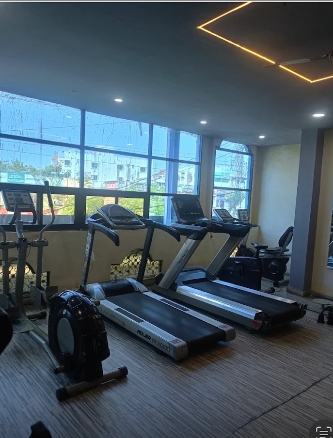 Treadmills and an exercise bike beside the windows at Bhandari Gym